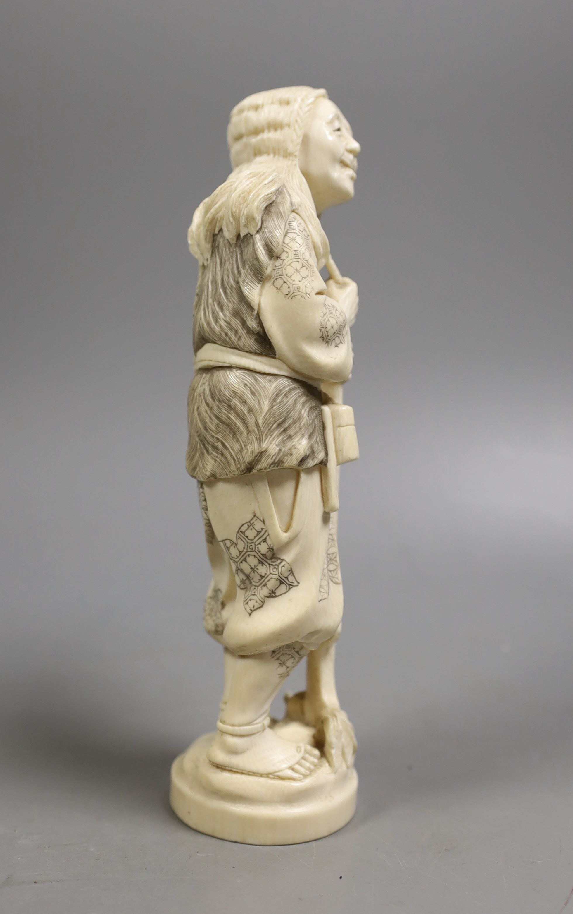 A Japanese ivory figure of a huntsman, early 20th century, 21 cms high.